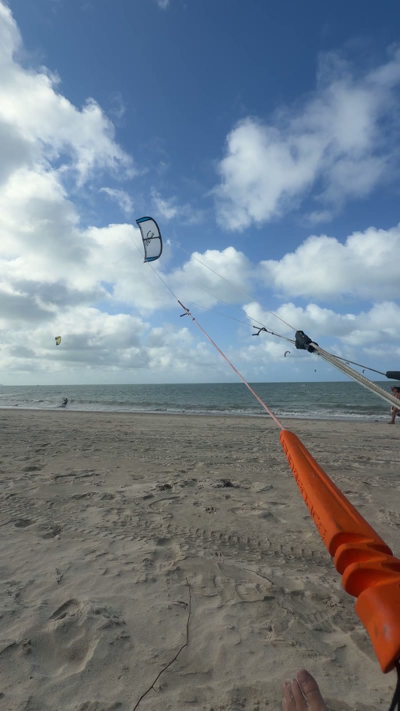 Linhas do kite subindo da barra em direção ao céu de Cumbuco