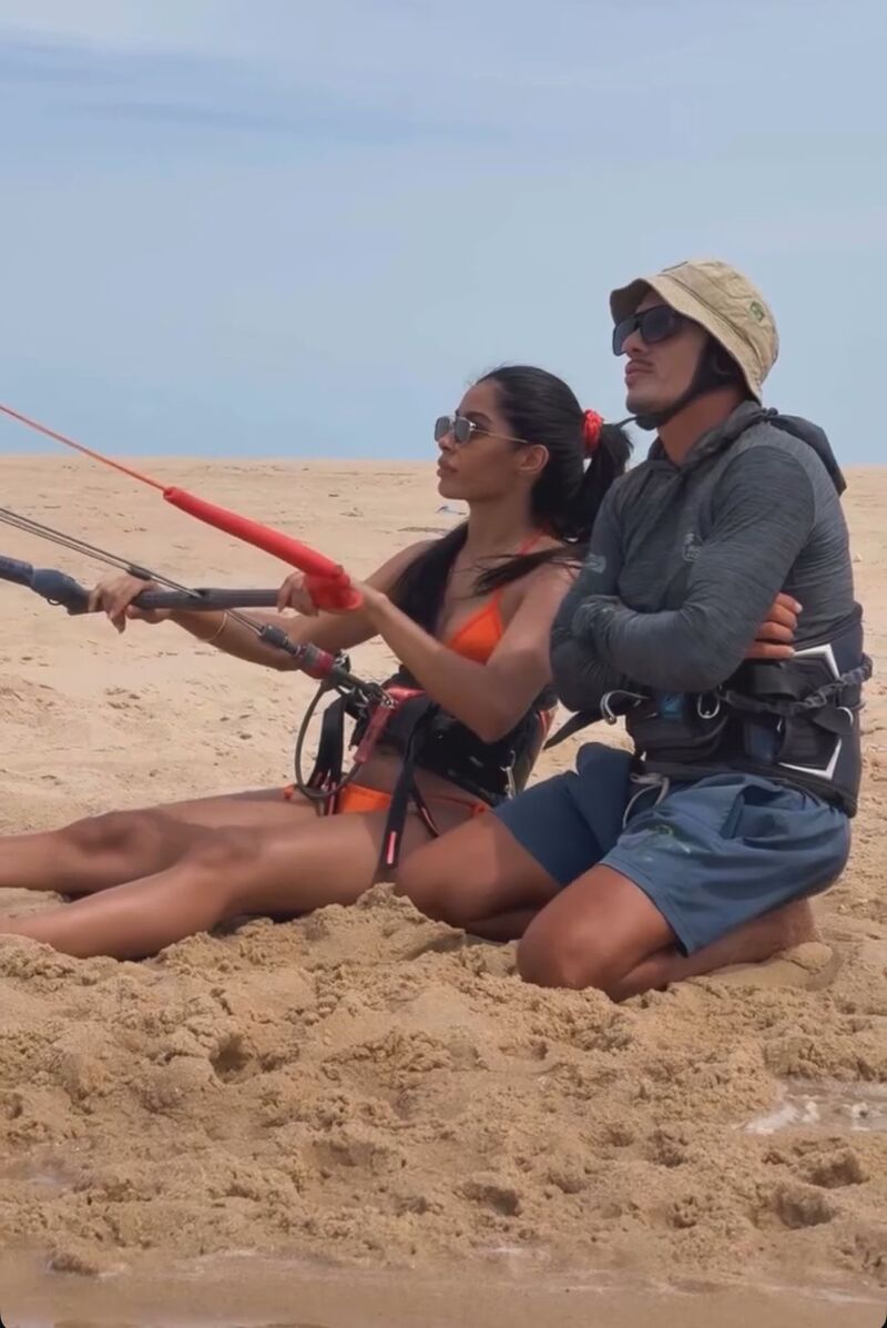 João orientando uma aluna com a barra do kite na areia de Cumbuco